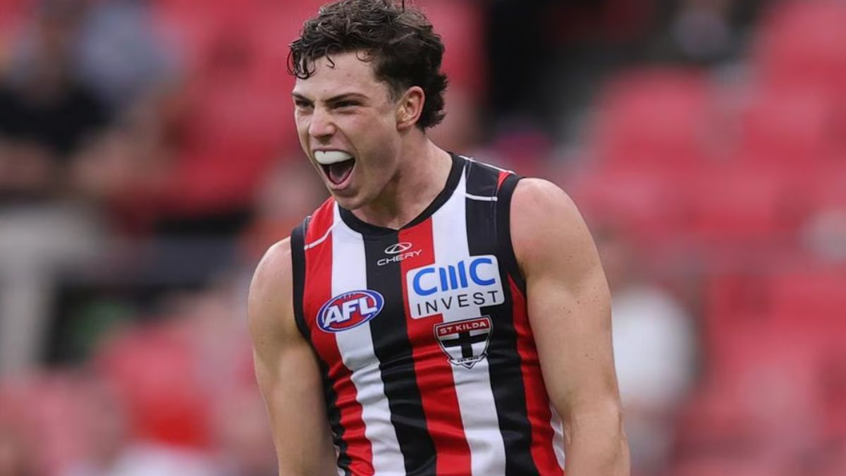 Australian rules football player in St Kilda jersey shouting with mouth open on the field, showcasing intense emotion and energy.